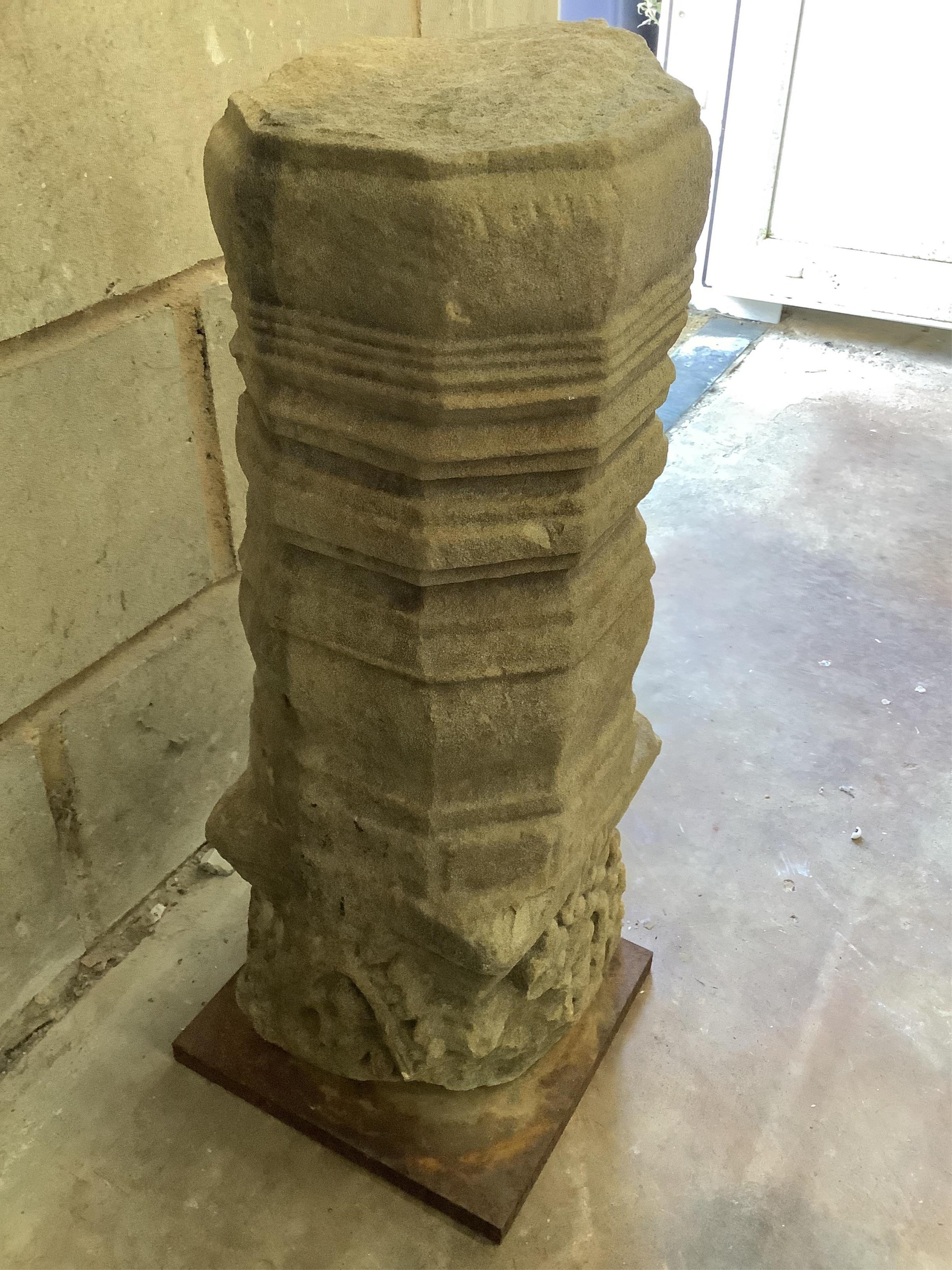 An Indian sandstone pillar with a wrought iron base, height 62cm. Condition - fair